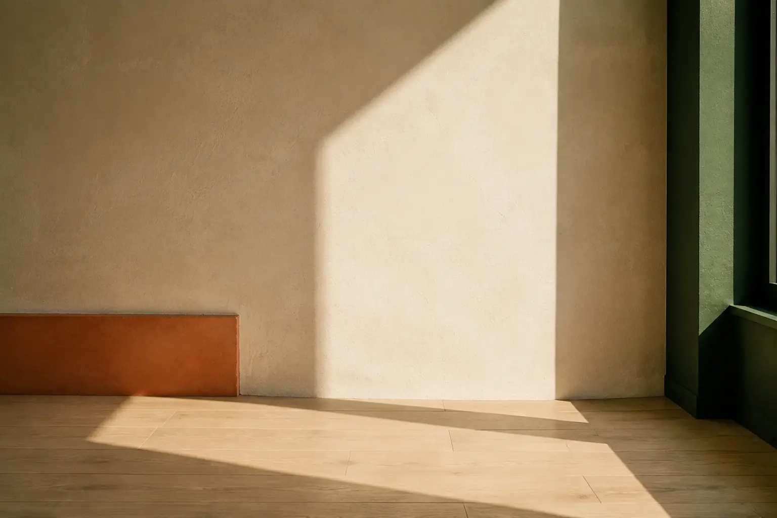 A sharp field of sunlight across an ivory wall and pale timber floor